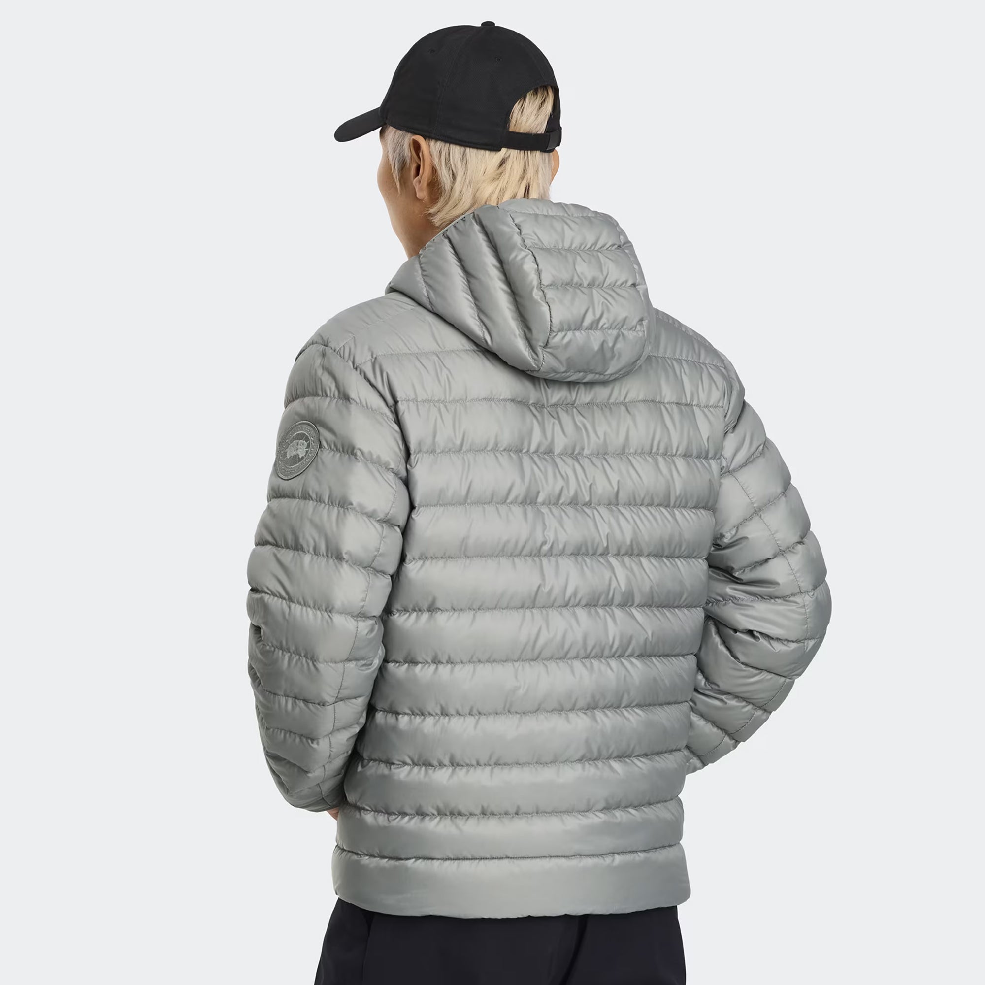 person wearing a grey jacket on a white background