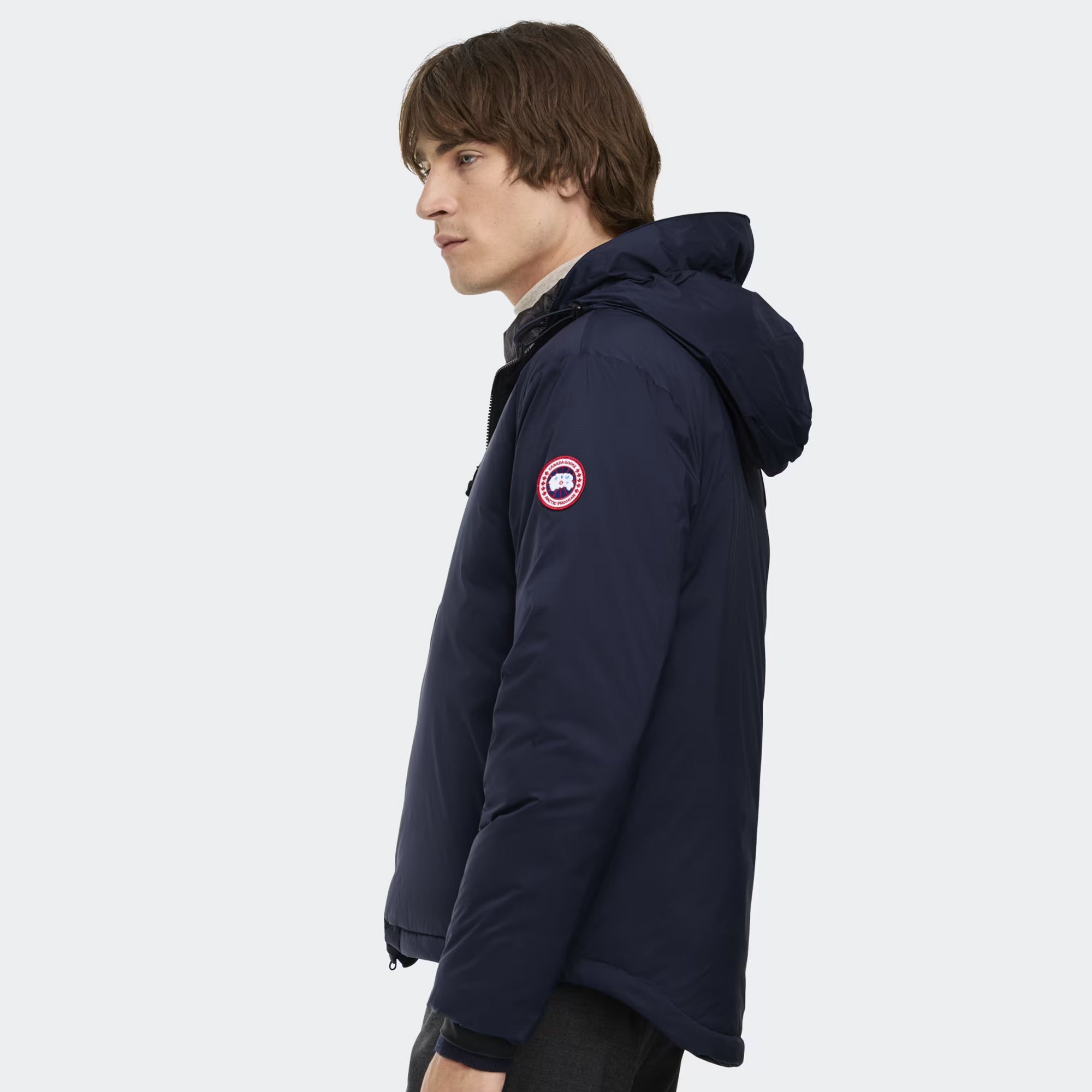 person wearing a navy and black jacket on a white background