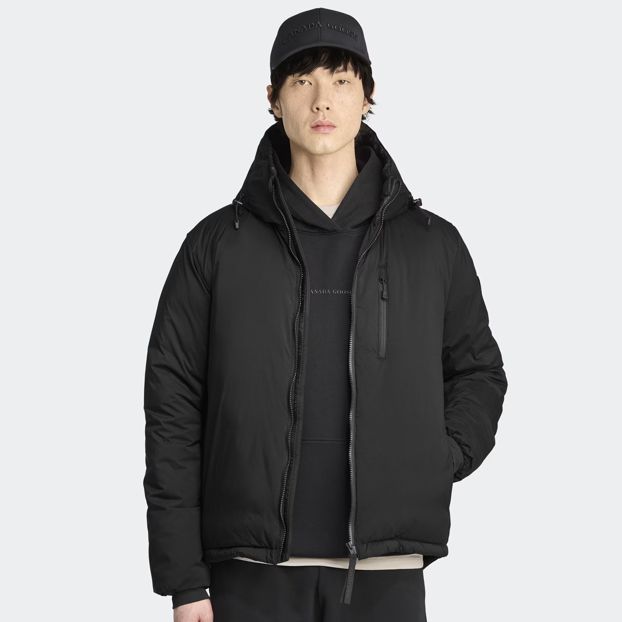 person wearing a black jacket on a white background
