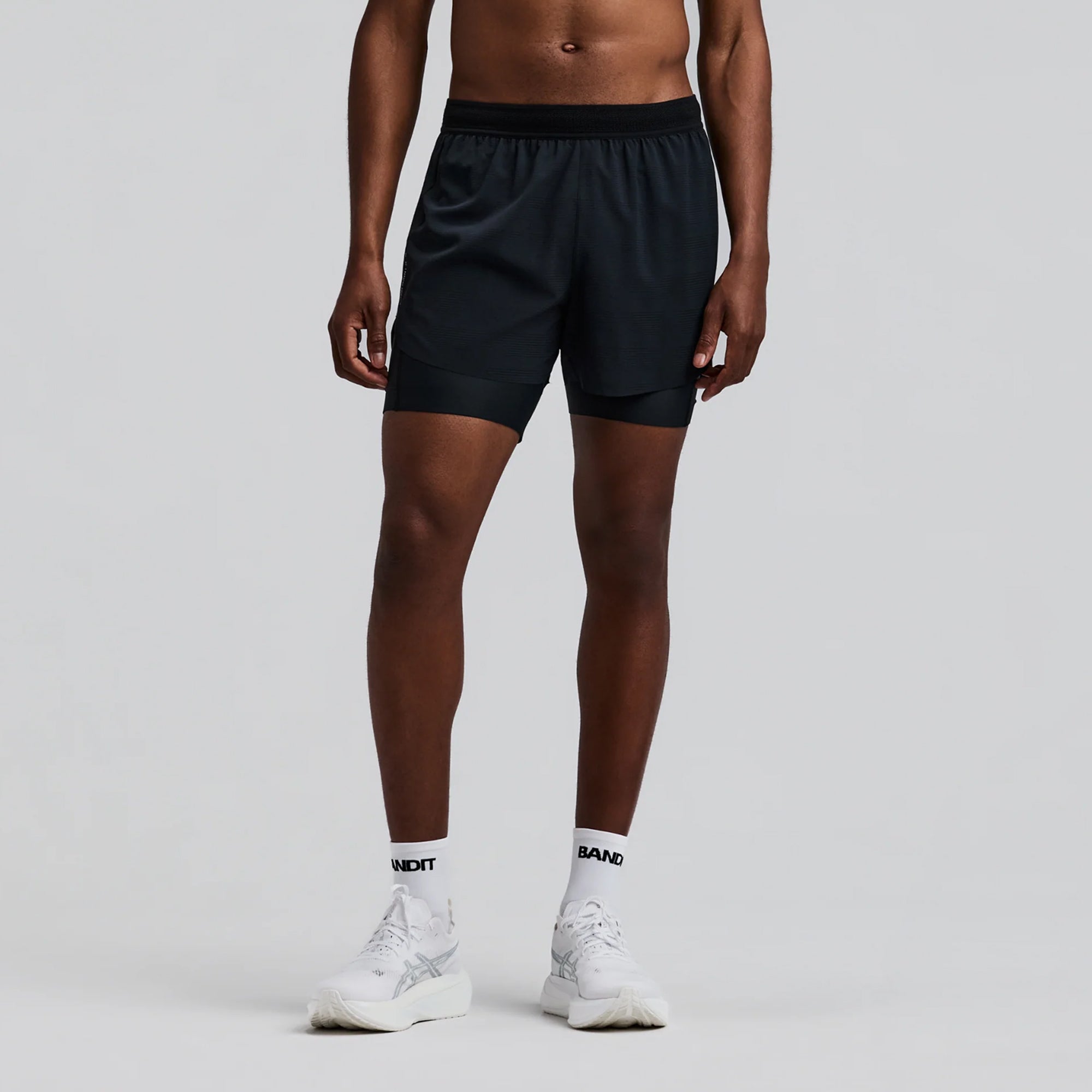 person wearing black shorts on a white background